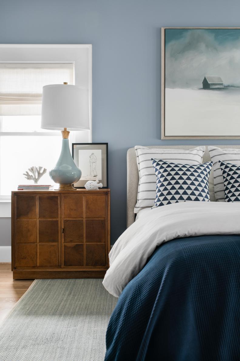 The master bedroom walls are painted a soothing blue-grey in a wipeable eggshell finish. This slight sheen helps play with the beautiful light coming in from the windows. If the walls get nicked or smudged from muddy pup noses or toddler hands covered in finger paint, a sponge will erase any trace of the foreign substances.