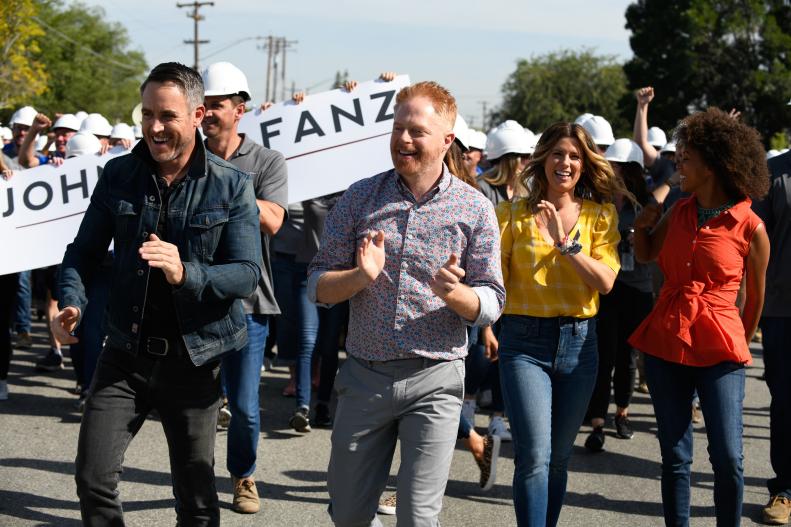 Host Jesse Tyler Ferguson, joined by designers Darren Keefe, Carrie Locklyn, and Breegan Jane, and builder Greg Balfanz of John Balfanz Homes, leads volunteers in the march to surprise the Mosely family of Bakersfield, California