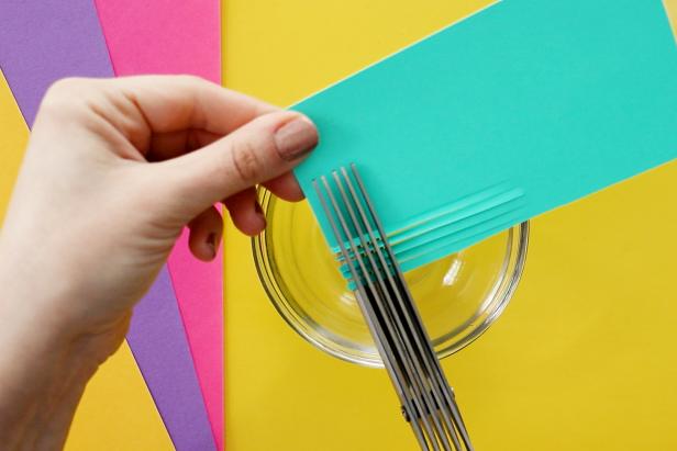 Make confetti by cutting scrapbook paper into small pieces. Optionally, use fringe scissors to cut more at once. Add sequins and any other small findings to your confetti.