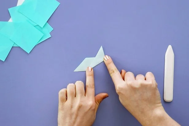 Fold your triangle in a diagonal accordion fold, using your bone folder to keep your folds sharp.