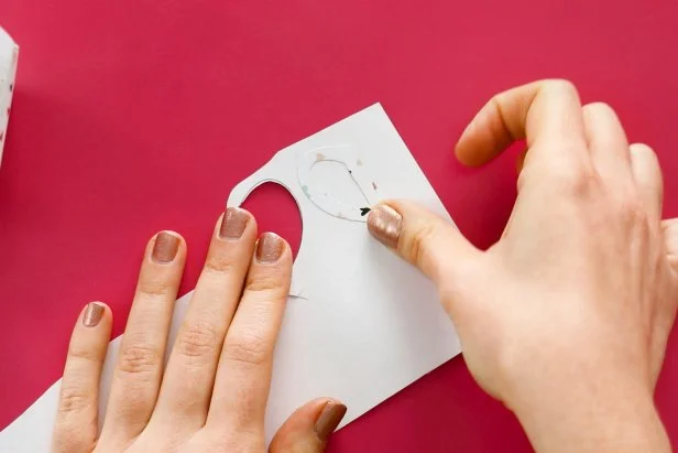 Cut out the handle from the pattern. Apply glue to just the handle and not the tab on the side. Glue it to the same scrapbook paper and cut out to get a two-sided handle. Fold the tabs back and push them through the line you cut earlier. Glue in place to form the teacup handle.