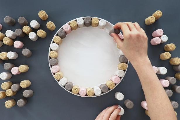 Use tacky glue to glue all of the corks inside the tray.