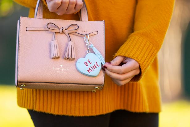 Woman Holding Purse With Heart Keychain That Says "Be Mine"