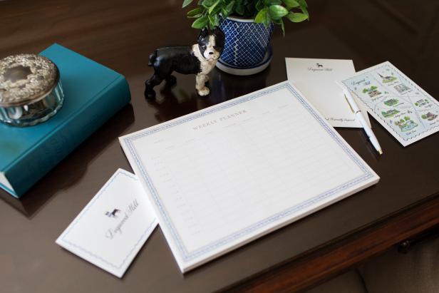 This desk features notepad paper and a dog figurine. 