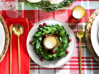 Easy décor can be created by using items together in groupings to create festive vignettes on the tabletop. Place a small wreath on a plate, and add a candleholder in the center. Add berries for an additional touch of color.
