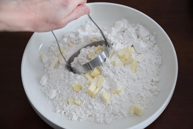 Place the flour in a large mixing bowl and add the butter. Use a hand chopper or pastry blender to cut the butter into the flour.