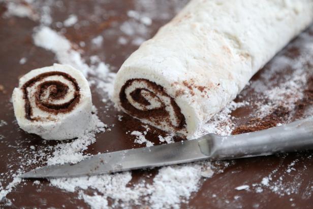 Beginning at a long end, roll the dough up jelly roll style. Use a sharp knife to cut the roll into 22 to 24 buns.