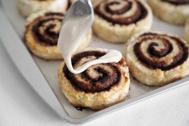 For the glaze, in a medium mixing bowl, combine the powdered sugar, heavy cream and vanilla extract. Whisk briskly until a thick pourable glaze forms. Spoon the glaze over the cinnamon rolls and allow them to stand until the glaze crusts, about 10 minutes.