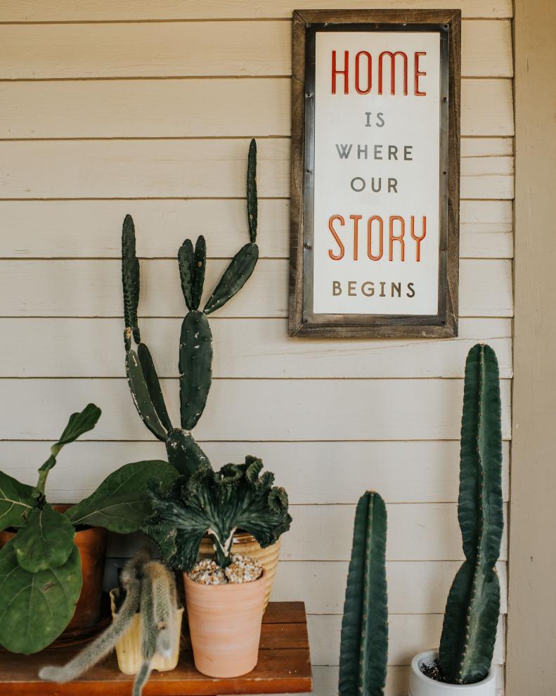 The friendly vibe of the Tucciarone family is established right off the bat on their wide, welcoming front porch and this charming tableau of cacti and a cheerful artwork.