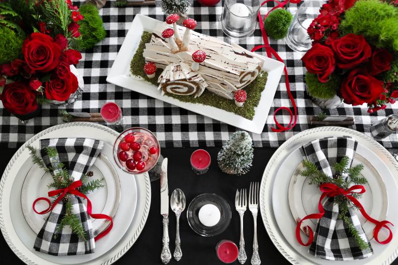 A black tablecloth is an ideal base for a black and white buffalo plaid table runner and matching napkins. This crisp, wintry color scheme is warmed with touches of vivid red and accented with rustic details. The woodland details add a cozy theme to make this table especially inviting to your guests.