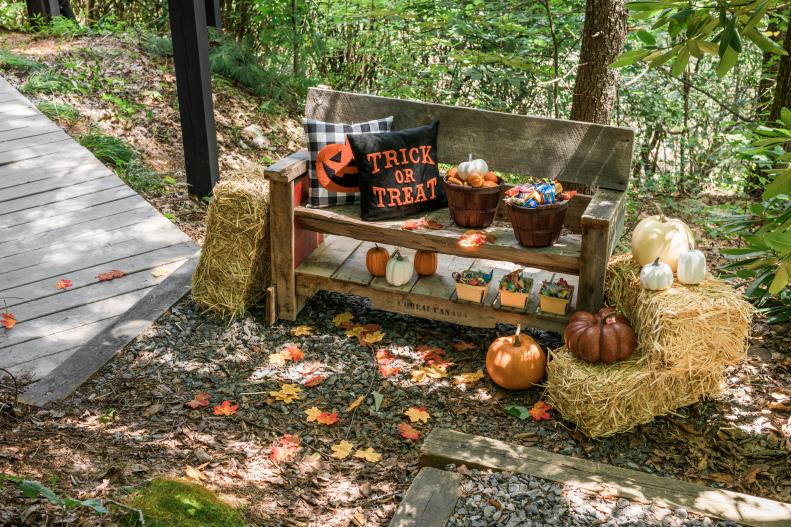 Let friends and neighbors help themselves to treats by displaying your Halloween candy in festive ways. A celebration of Fall is in full effect with this bench tricked out with apple baskets, bales of hay, and pumpkins.