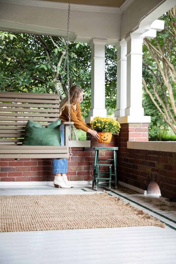 A Woman Placing a Mum on a Front Porch