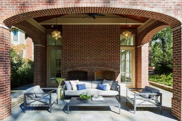 This covered patio includes a fireplace and log storage.