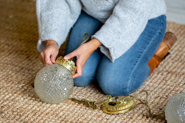 This vintage light fixture is being disassembled and the glass globes are being utilized as part of an oversized Christmas ornament DIY.