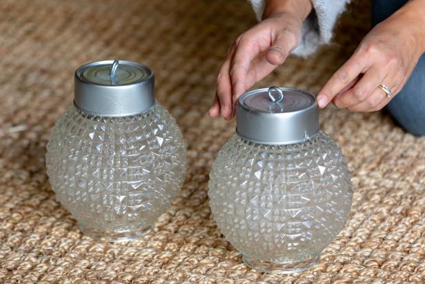 These recycled tuna cans have been cleaned, painted and modified to rest on top of these vintage glass light fixture globes for a DIY oversized Christmas ornament. The cans are attached to the glass globes using hot glue.