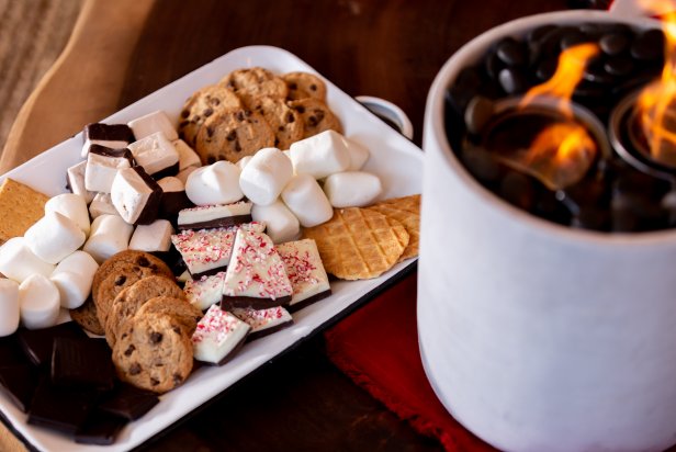 This white platter is overflowing with creative, out-of-the-box ingredients for s'mores. The DIY tabletop fireplace is the perfect spot for roasting marshmallows to combine with delicious peppermint bark, dark chocolate, chocolate chip cookies and waffle cone wafers.