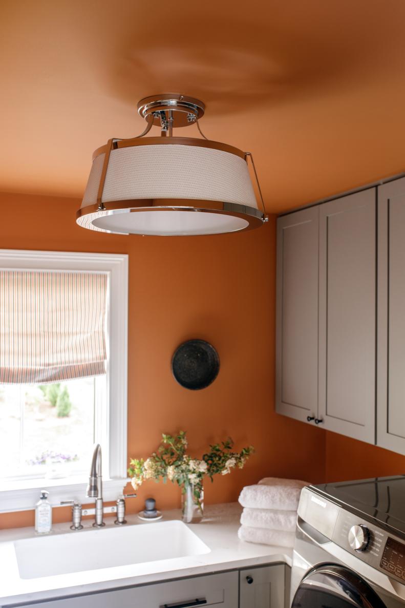 The 3-light semi flush mount light on the laundry room ceiling has a chrome finish and richly textured fabric shade, with a domed bottom diffuser that casts a beautiful glow.
