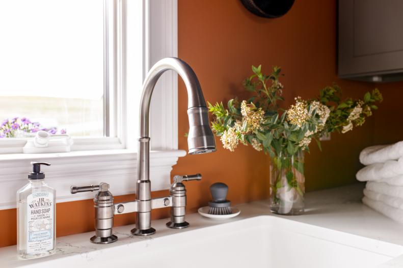 The laundry room’s white undermount sink includes a two-handle pull-down bridge sink faucet. The spacious sink for hand-washing delicate items and household chores is surrounded by a durable engineered quartz top that offers space for folding clean towels, or decorative accessories that make the space more cheerful. 