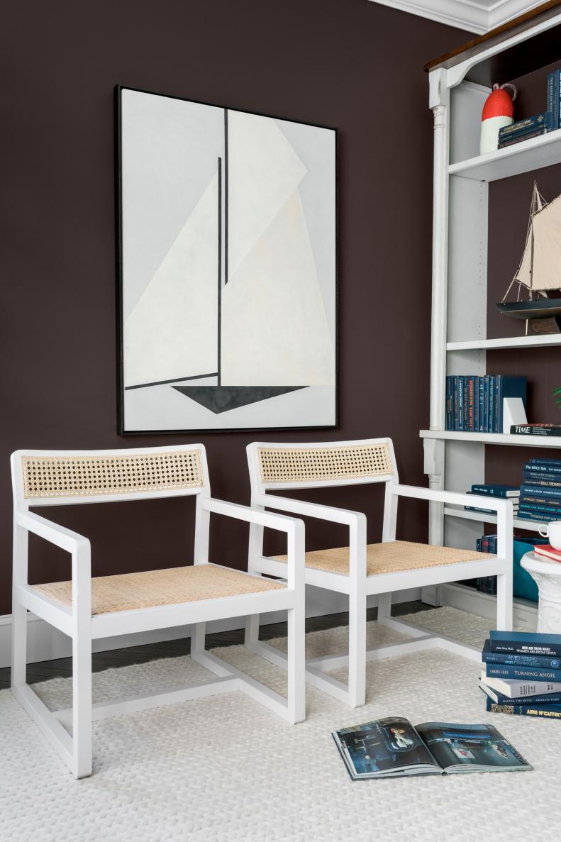 Two cane armchairs provide an easy way for parents to help kids with homework at the desk, or for someone at home to quickly join a conference call. The commissioned abstract wall art above the armchairs reflects the home’s coastal location. “He used plaster and put together all these different triangles, and then connected them for an abstracted take on a sailboat silhouette,” says designer Brian Patrick Flynn. 