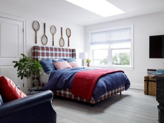 White bedroom with plaid upholstered bedframe and red and blue bedding
