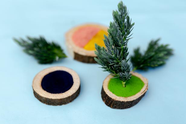 This miniature Christmas tree is made by attaching free greenery cuttings and hot gluing them to small craft wood rounds.