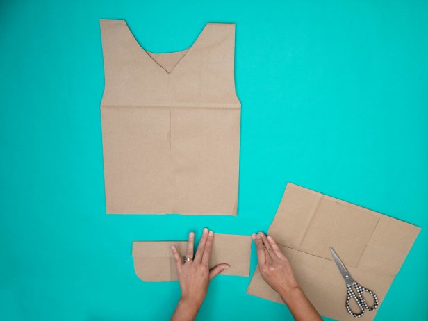 This DIY fisherman's Halloween costume is made from paper grocery bags cut into a fisherman's vest. Paper pockets have been cut out and are folded then glued on.