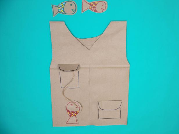 These colorful paper bag fish have been glued to twine and glue to this DIY paper bag Halloween costume that looks like a fishing vest.