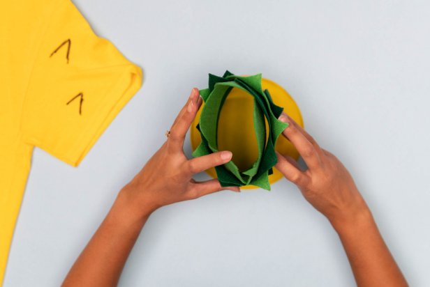 This pineapple top is part of a Halloween costume made from a yellow t-shirt, felt and other craft supplies.