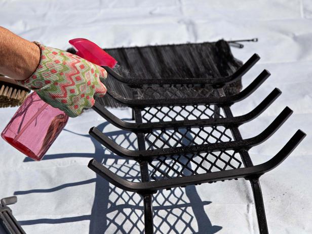 Lay out a large tarp that will fit the screen, grate and fireplace tools. Spray everything down with equal parts white vinegar and warm water. Use a nylon brush to scrub away the soot.