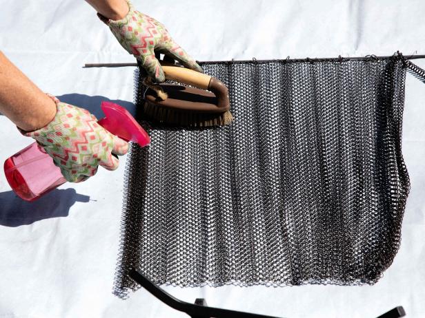 Lay out a large tarp that will fit the screen, grate and fireplace tools. Spray everything down with equal parts white vinegar and warm water. Use a nylon brush to scrub away the soot. For stubborn spots, try steel wool. Be sure to clean both sides of the screen.