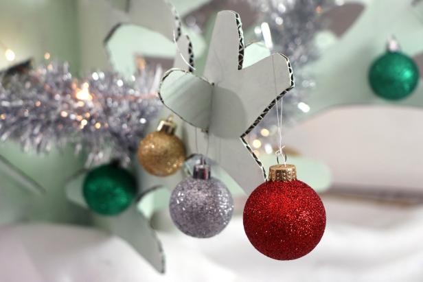 Once the paint is dry, put the branches back in place and then trim your tree with a tree skirt, tinsel, and lightweight ornaments.