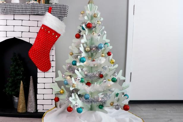 Once the paint is dry, put the branches back in place and then trim your tree with a tree skirt, tinsel, and lightweight ornaments.