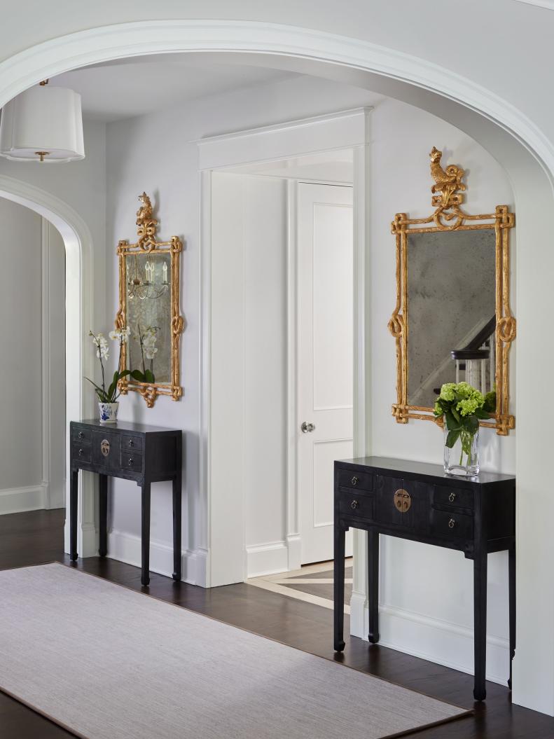 This foyer entrance includes matching gilded mirrors.
