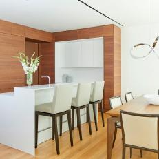 Modern Brown Kitchen and Dining Area With Silver Pendant