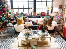 Open plan loft with colorful Christmas tree, sofa and coffee table. 