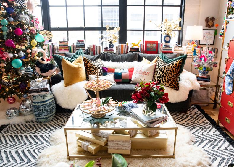 Open plan loft with colorful Christmas tree, sofa and coffee table. 