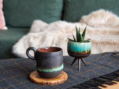 Painted ceramic mug and succulent pot on a coffee table