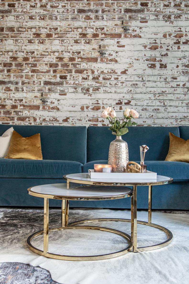To complement and elevate the industrial look of the brick wallpaper, Kati continued her use of metallics from the entryway. The table, accessories and pillows all sport metallic shades, materials or finishes that look clean and polished, paired with the layered, neutral-toned rugs in the space.