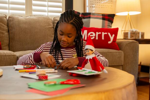 Elf on the Shelf ® is a game played at Christmastime where a Scout Elf visits from the North Pole to see who made Santa's nice list. Each night, after kids are in bed, parents move the elf into different poses. This elf is prepared to help kids make their own Christmas cards.
