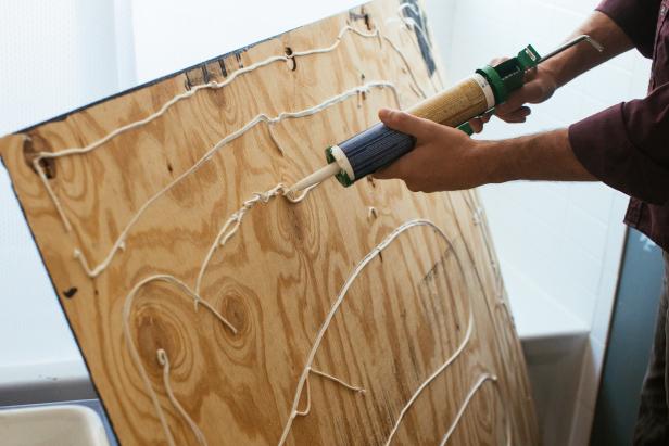 Apply a generous amount of adhesive to the back of the beadboard panels and press against the wall.