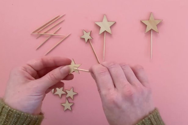 Add a toothpick to the dab of hot glue on the back of the wooden star.
