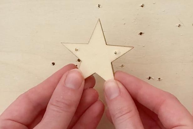 Use an electric drill to add two holes on each side of the wooden star. This will allow a thread to be placed through the star to create the garland.