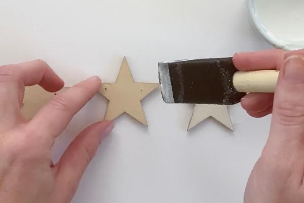 Use a sponge brush to apply a thick layer of decoupage glue to the wooden star.