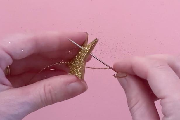 Thread the glitter wooden star with an embroidery needle through the two drilled holes.