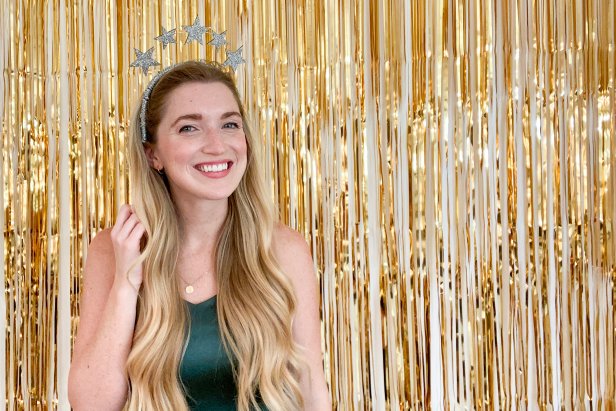 Woman Wearing Glitter Star Headband in Front of Gold Fringe Backdrop