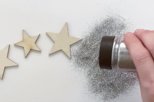 Shake on a thick layer of glitter to the decoupage glue on the wooden stars.