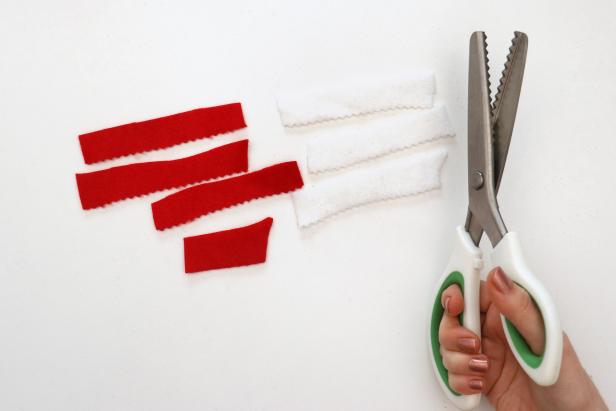 Use pinking shears to cut strips of felt. Cut three strips in red and three in white, along with a small extra piece of red felt.