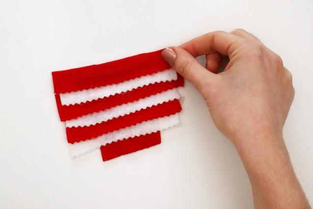 Add a line of hot glue to the top of each piece and glue on the next one, to form a decorative pattern of zig zag stripes. Glue a larger piece of felt to the back.