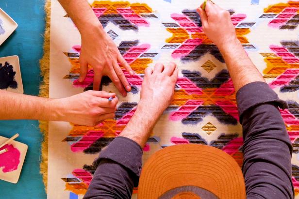 Using stencil to paint pattern onto handmade jute rope rug.
