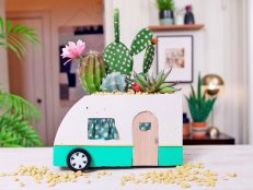 Concrete planter made to look like vintage camper filled with cacti